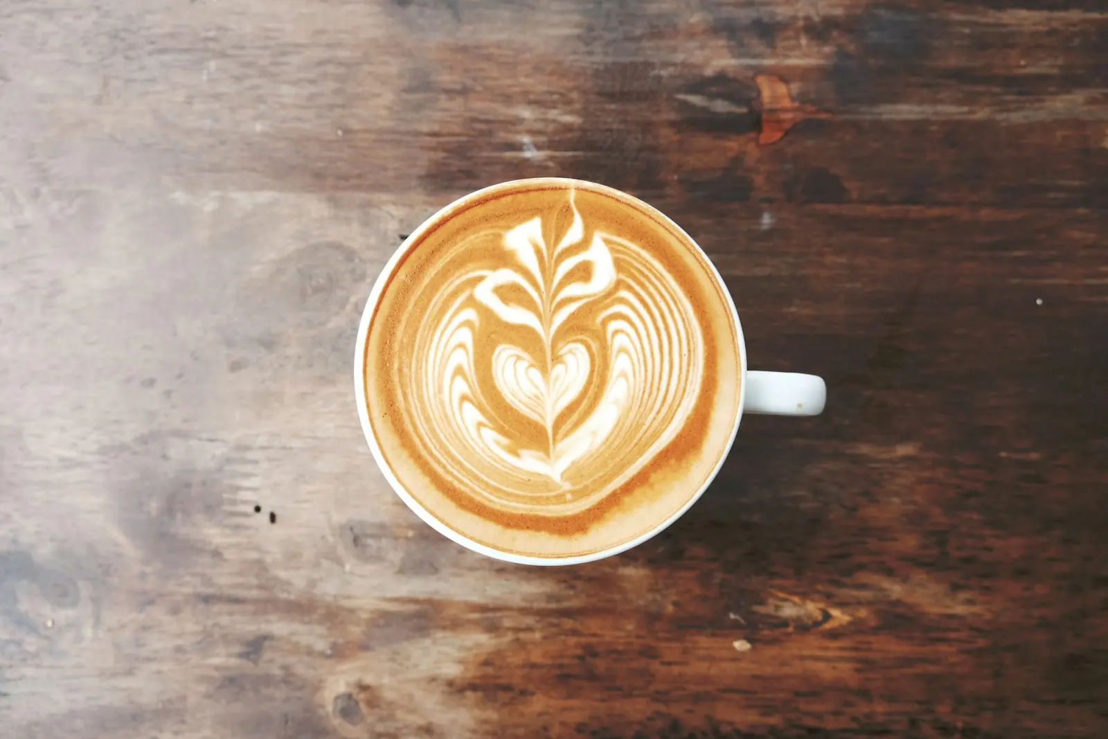 Ilustrativna fotografija: kafa sa latte artom na drvenom stolu